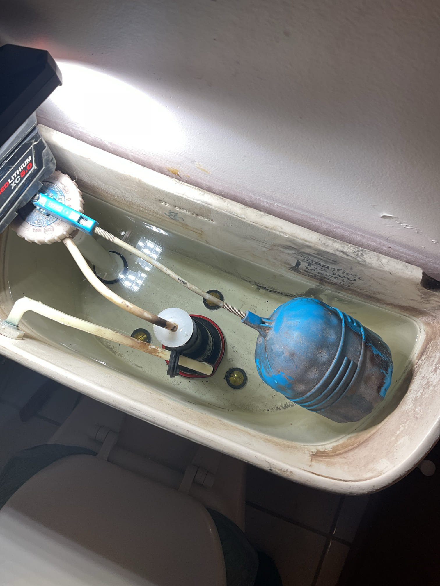 Upon inspection, the toilet was found to be rocking at the base and leaking from that location, indicating a failed seal and improper mounting. We recommended pulling and resetting the toilet with a new seal and proper anchoring to stop the leak, restore stability, and prevent potential water damage. The water supply was already shut off; remaining water was vacuumed, the supply line and closet bolts were disconnected, and the toilet was removed for inspection.

After removal, the toilet flange was found to be rusted and set well below the finished floor, preventing the wax seal from properly compressing during the homeowner’s prior repair attempt. Due to the deteriorated condition of the metal flange, the toilet could not be securely fastened or sealed. We recommended replacing the metal flange and raising it to floor level to ensure a proper, leak-free installation. The damaged flange was removed, a new repair flange was installed and secured to the floor, and plastic spacers were ad