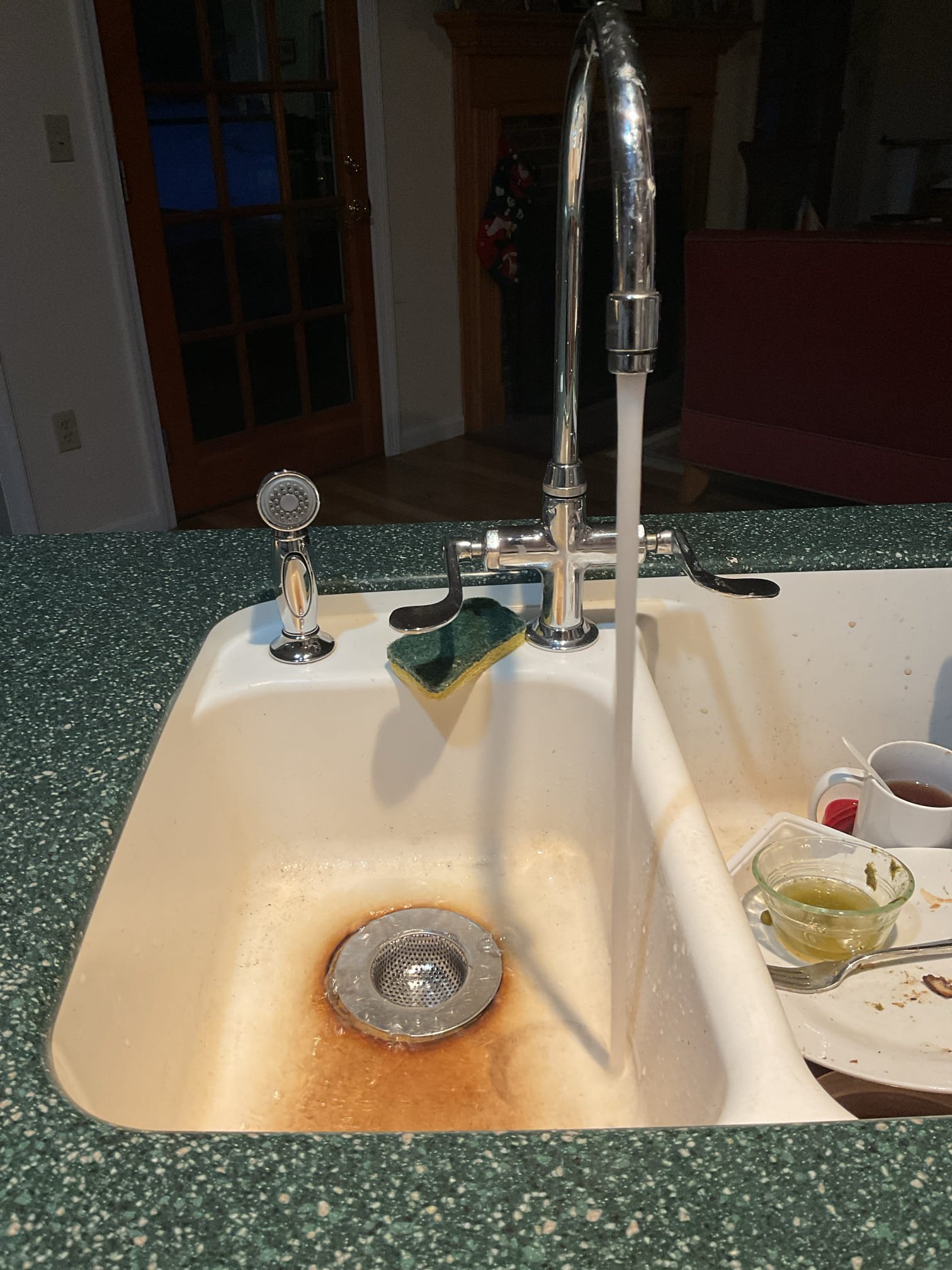 The kitchen faucet side sprayer hose was torn and leaking, causing improper operation. We replaced the sprayer hose and spray head, cleaned the sink base, installed a new escutcheon, and tested the fixture after restoring water, confirming proper operation with no leaks present at this time.