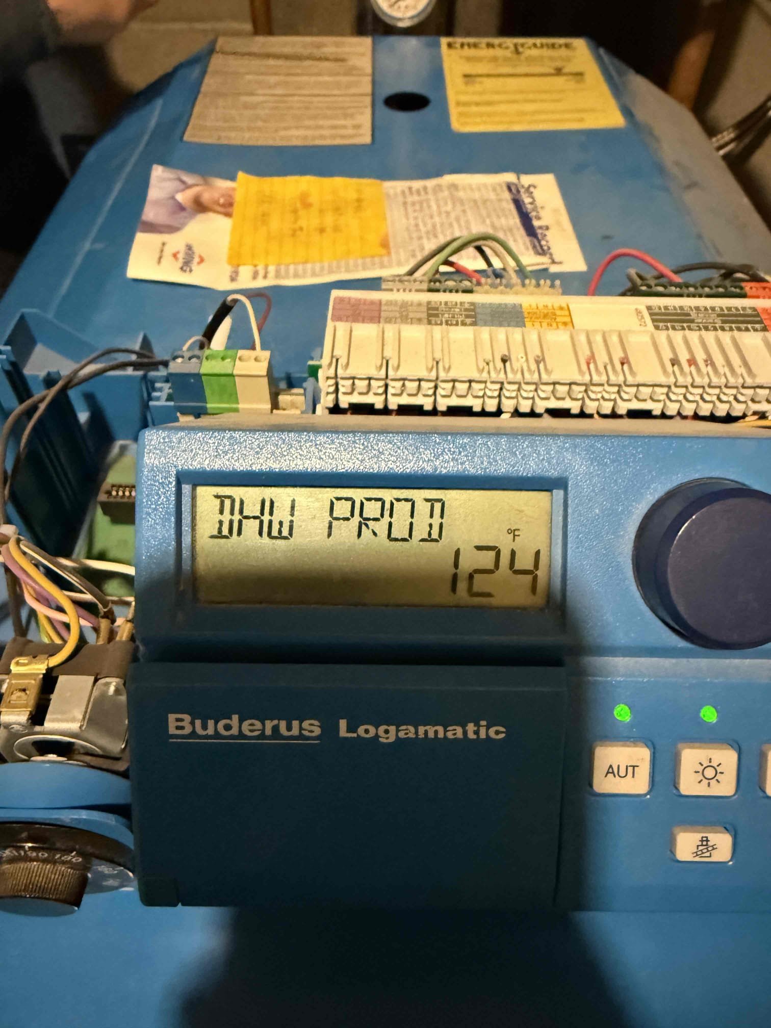 The customer reported a DHW (Domestic Hot Water) error on a Buderus oil boiler. Upon inspection and testing, the DHW temperature sensor was found to be faulty. The failed sensor was replaced with a new one. After installation, hot water temperature at the faucet was tested and measured 140°F. The temperature was then adjusted down at the Logamatic control. A follow-up test at the faucet showed a stable temperature of 120°F. The new sensor was verified to be satisfied at 120°F and stopped calling for hot water as designed. The system is operating properly at this time.