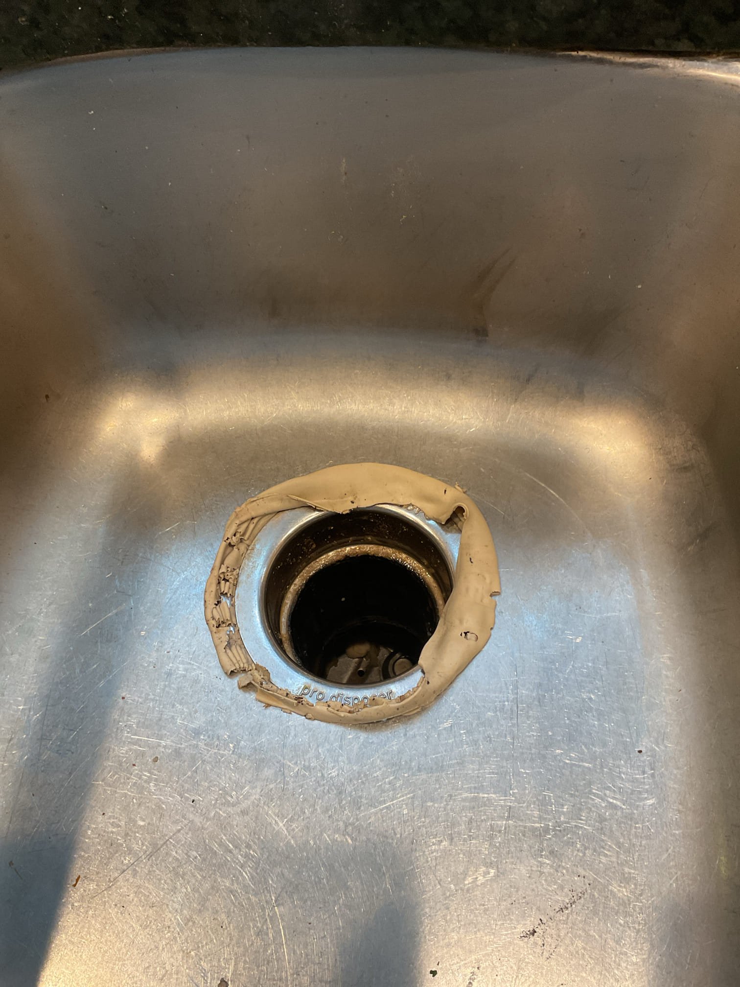 The garbage disposal mounting screws had come loose, causing the unit to shift and leak. Installed new screws to secure the disposal and re-applied plumber’s putty to the basket strainer to restore a watertight seal.