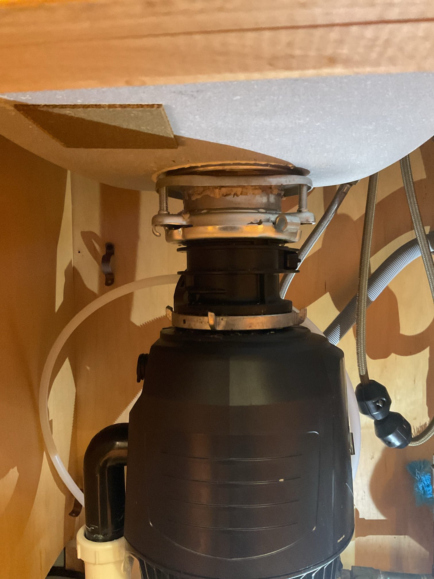 The garbage disposal mounting screws had come loose, causing the unit to shift and leak. Installed new screws to secure the disposal and re-applied plumber’s putty to the basket strainer to restore a watertight seal.