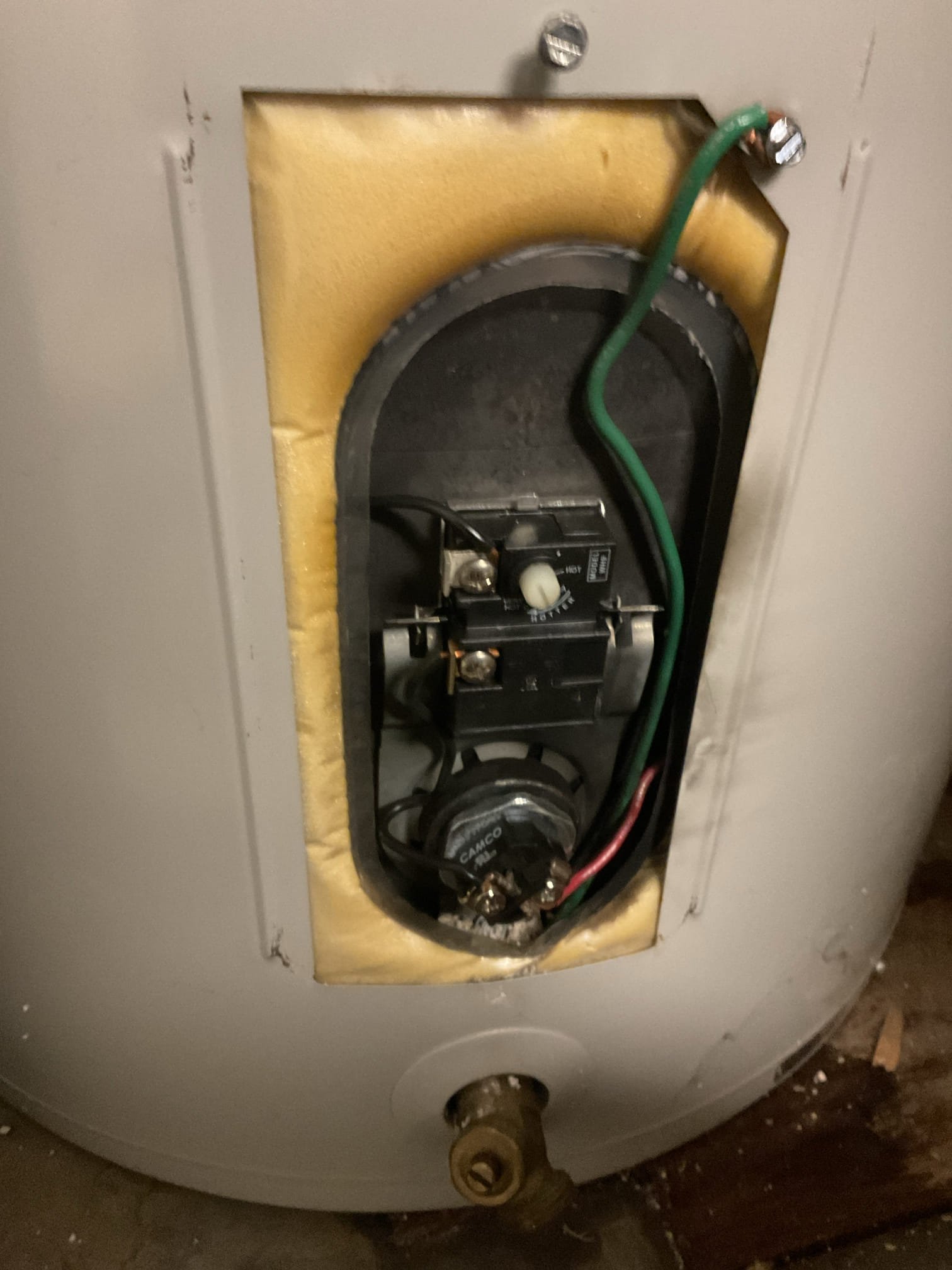 The electric water heater was not producing adequate hot water due to a failed lower heating element and significant scale buildup inside the tank. Upon inspection and discussion of the unit’s condition, it was determined that the lower element—previously replaced approximately four years ago under similar circumstances—had failed again. Due to the age of the water heater and the extent of calcium buildup, replacement of the unit was recommended; however, the homeowners elected to replace the lower element and flush the tank to extend the service life of the existing unit.

Power to the water heater was shut off and the tank was fully drained before removing the failed lower element, which was found to be severely deteriorated from calcium buildup, with visible scorching on both the plastic and metal components. The interior of the tank contained heavy scale accumulation above the element level; approximately one gallon of scale was removed using a vacuum. A new lower heating element w