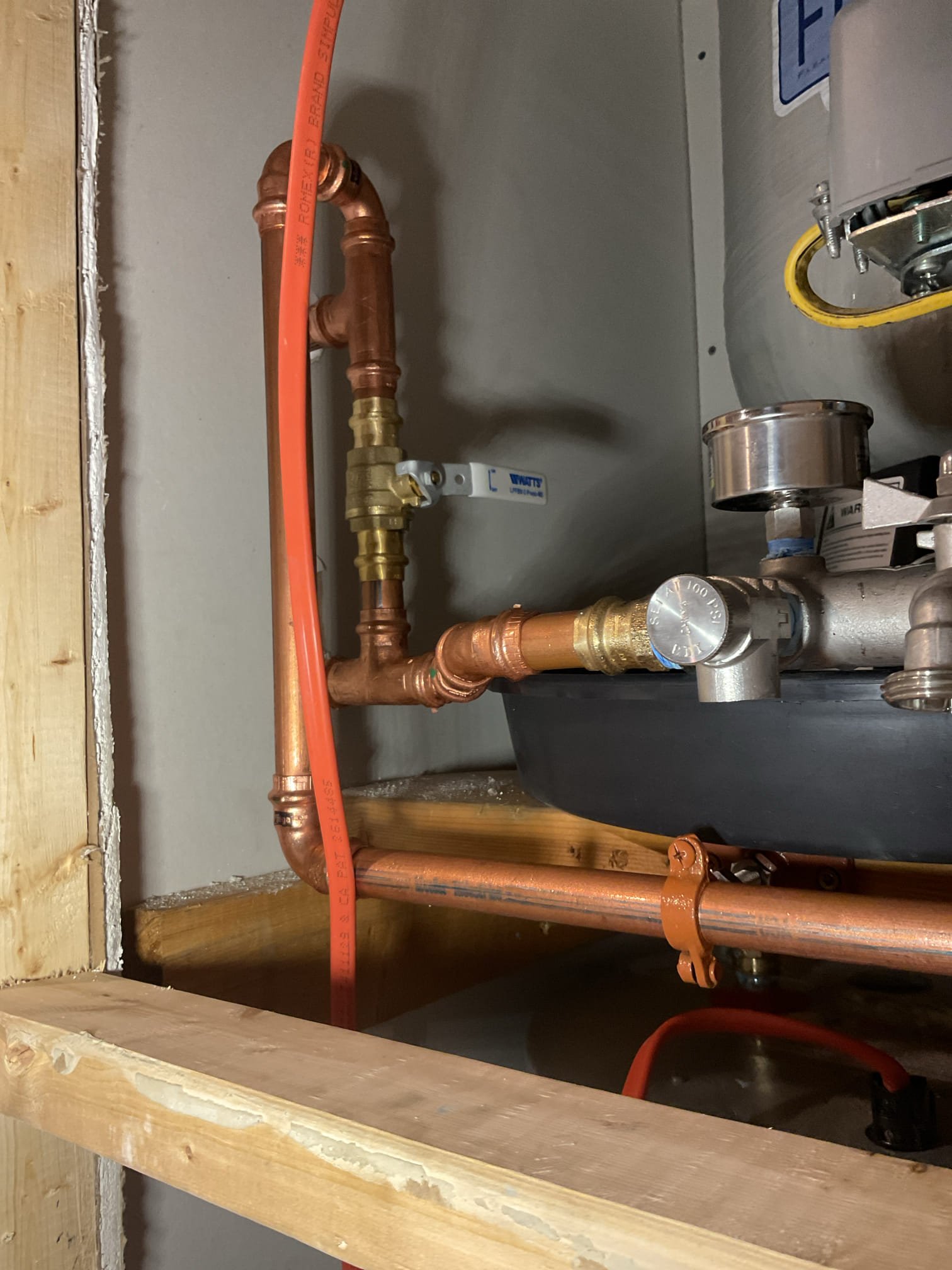 We found that the water system was not properly configured, with the pressure tank not serving as the starting point of the system and portions of the water heater piping not meeting current code requirements. We recommended redirecting the water lines to properly position the pressure tank and reworking the water heater piping to meet code, improving overall system reliability, efficiency, and safety.

The existing PEX piping to the pressure tank and water heater was cut out and removed. A new sediment filter housing with a three-valve bypass was mounted to the left of the mechanical space to allow filtration and easy isolation for maintenance. The filter housing was secured to the ship-lath siding, a boiler drain was installed on the outlet to relieve pressure during cartridge changes. The homeowner was instructed on proper cartridge replacement procedures.

New piping was installed from the existing poly water line below the residence up through the floor to the pressure tank inlet.