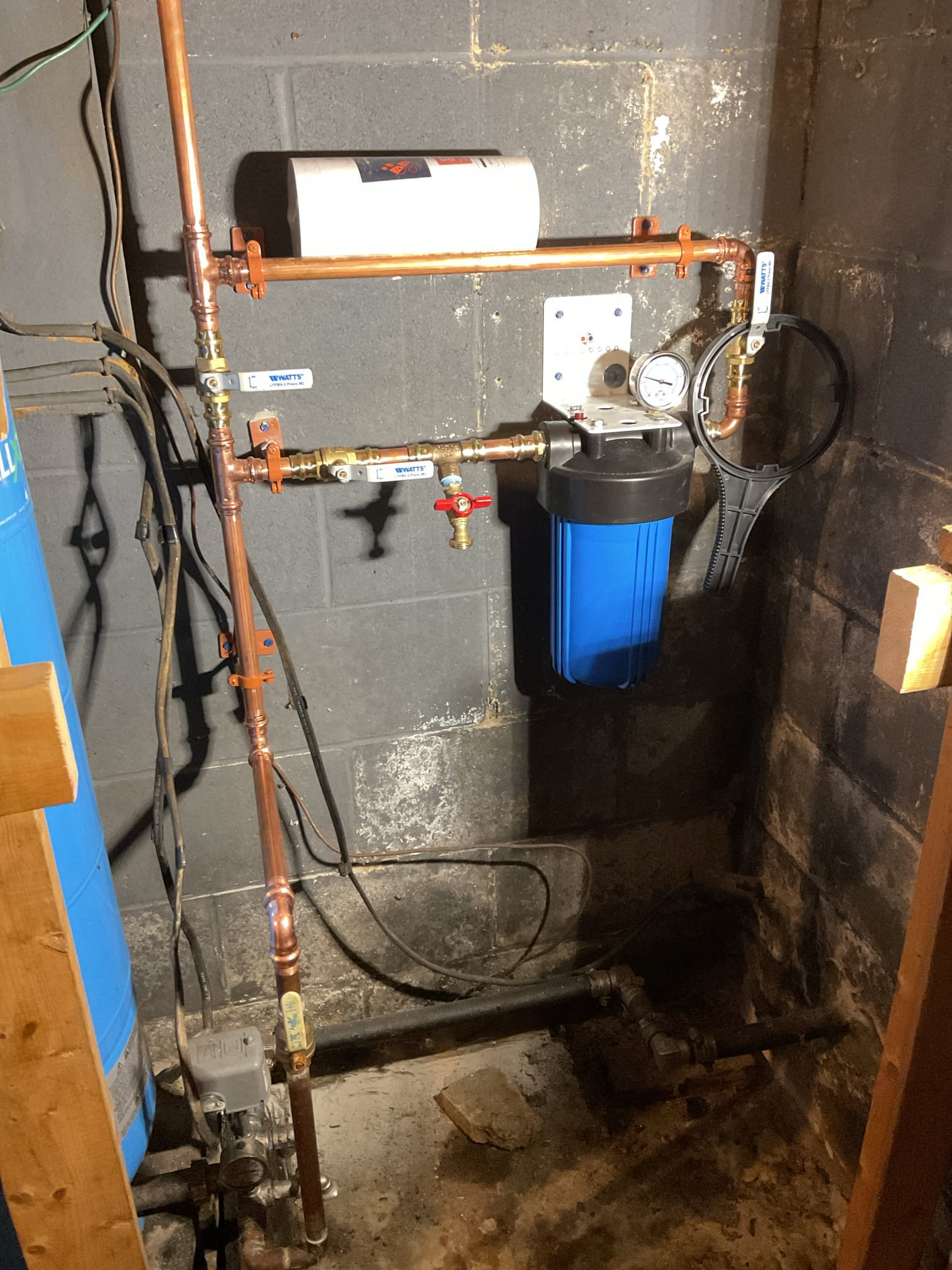 Upon arrival, the homeowner reported issues with the tub spout not diverting properly to the shower, as well as a significant drop in water pressure throughout the home. When multiple fixtures were used simultaneously, water flow would stop entirely at one or more fixtures. After observing the issue, the mechanical room was inspected and it was noted that the pressure tank had been replaced in 2018 and the system contained an older sediment filter with no bypass installed. Based on the age and condition of the filter, along with the pressure symptoms, it was determined that the filter was restricting water flow and contributing to the pressure loss.

Due to the condition and design of the existing filter housing, which lacked a bypass and showed signs of restriction, replacement was recommended. A new 4.5” x 10” filter housing with a 3-valve bypass system was advised to improve water pressure, simplify filter servicing, and increase overall system reliability.

The well pump power was 