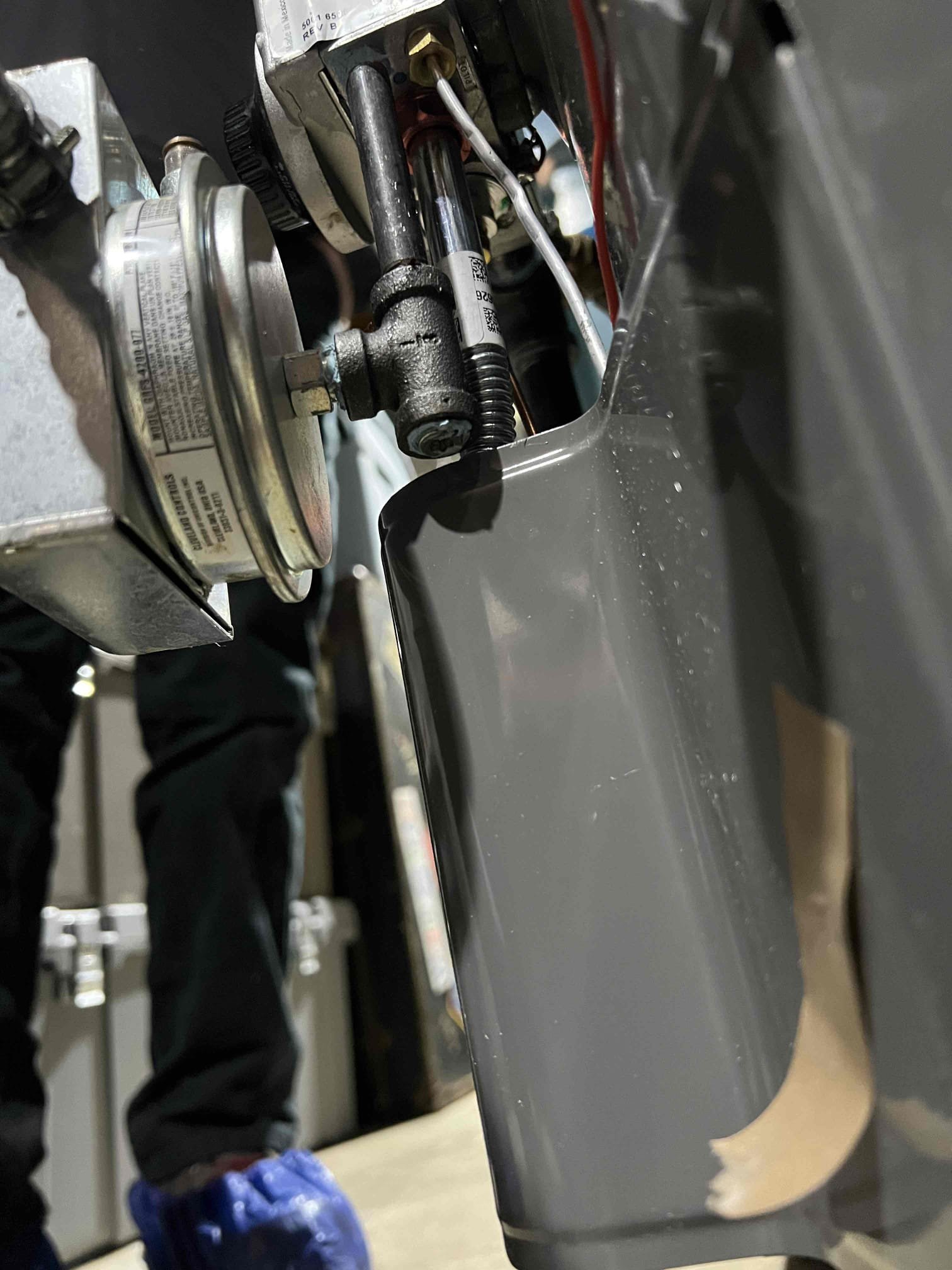 Arrived on site to investigate a no–hot water issue on a Rheem natural-draft propane water heater, installed by us in December 2025. Upon inspection, we found the combustion air safety had tripped and the burner and burner orifice were sooted. We contacted technical support, who had us verify the manifold gas pressure, which was within manufacturer specifications.

This water heater is common-vented into the chimney with a propane boiler. Based on their findings, technical support recommended reworking the venting. They are sending a replacement combustion air safety directly to the customer. We will verify local venting codes and make any necessary vent modifications once confirmed.