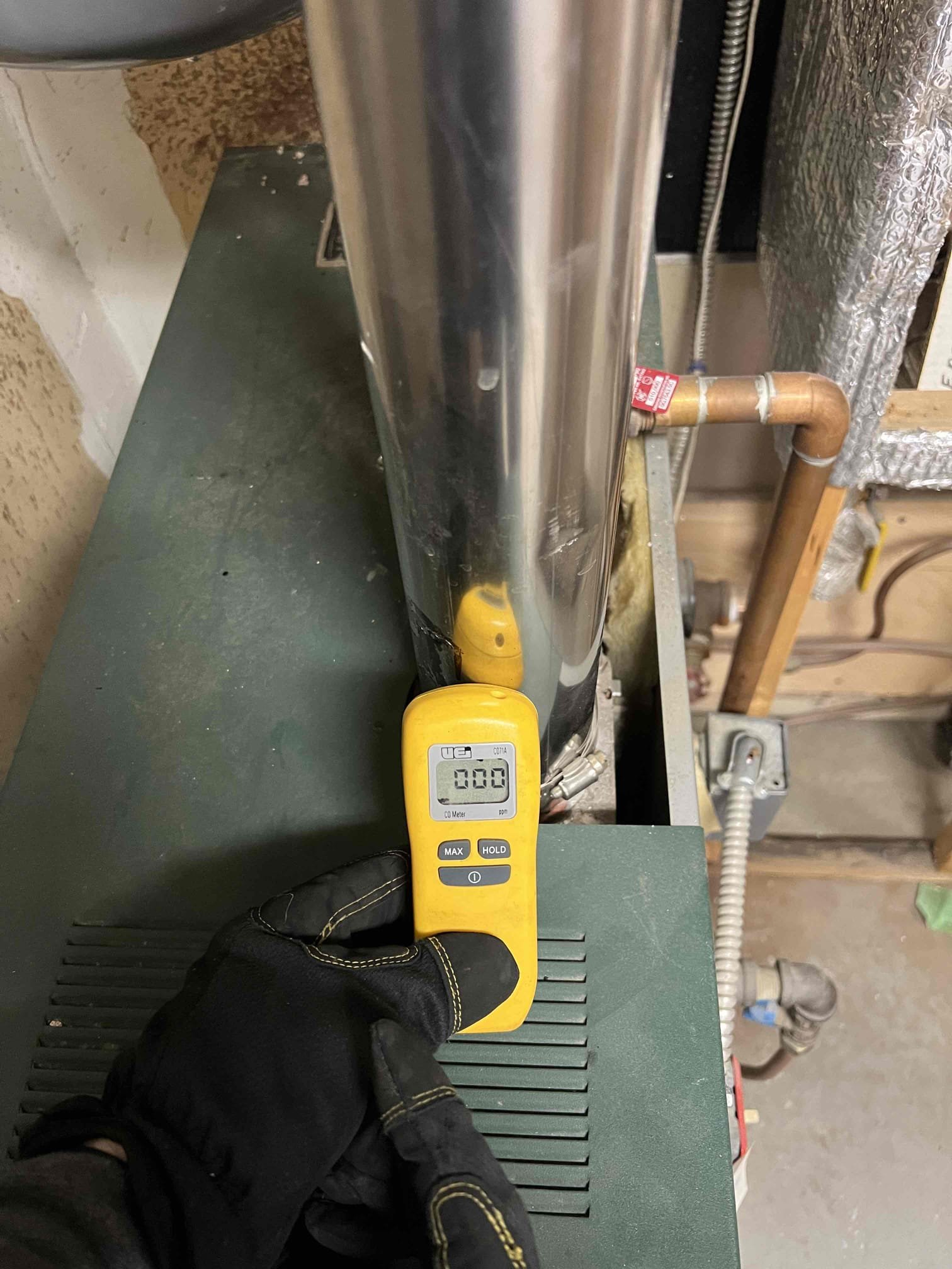 Arrived onsite to investigate a burning smell coming from the boiler. The boiler is located in the garage, and upon entry a burning odor was present. I found insulation resting on top of the boiler and observed black staining on the exhaust pipe, which I believe to be the source of the smell. Carbon monoxide levels were checked and no leaks were detected. Verified proper operation; the system is working properly at this time.