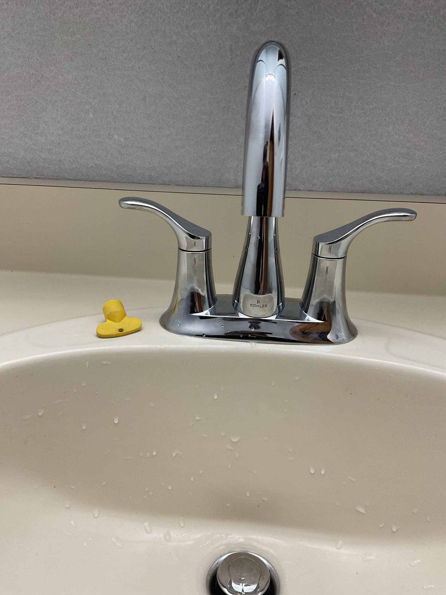 The downstairs toilet was previously found to have a cracked tank caused by freezing conditions, which compromised the integrity of the unit and created a risk of leaks and further damage. The existing toilet had been removed during a prior visit and the toilet flange replaced. During this visit, the new customer-supplied toilet was assembled and installed, secured to the flange using new toilet bolts, wax ring, and supply line. The toilet was tested through multiple flush cycles with no leaks observed at this time. A bead of caulking was applied around the base of the toilet to provide additional stability and allow for easier cleaning.

The existing bathroom lavatory faucet was found to be corroded and no longer operating reliably. The old faucet and pop-up assembly were disconnected and removed, and all mounting surfaces were thoroughly cleaned. A new Kohler Simplice faucet was installed along with new supply lines, pop-up assembly, and P-trap. Water was restored and the faucet was 