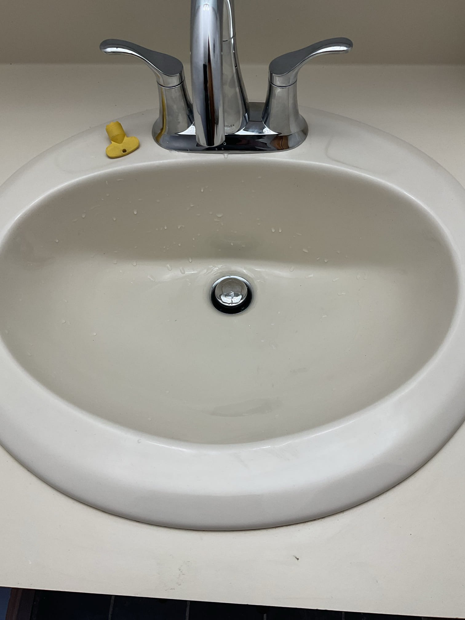 The downstairs toilet was previously found to have a cracked tank caused by freezing conditions, which compromised the integrity of the unit and created a risk of leaks and further damage. The existing toilet had been removed during a prior visit and the toilet flange replaced. During this visit, the new customer-supplied toilet was assembled and installed, secured to the flange using new toilet bolts, wax ring, and supply line. The toilet was tested through multiple flush cycles with no leaks observed at this time. A bead of caulking was applied around the base of the toilet to provide additional stability and allow for easier cleaning.

The existing bathroom lavatory faucet was found to be corroded and no longer operating reliably. The old faucet and pop-up assembly were disconnected and removed, and all mounting surfaces were thoroughly cleaned. A new Kohler Simplice faucet was installed along with new supply lines, pop-up assembly, and P-trap. Water was restored and the faucet was 