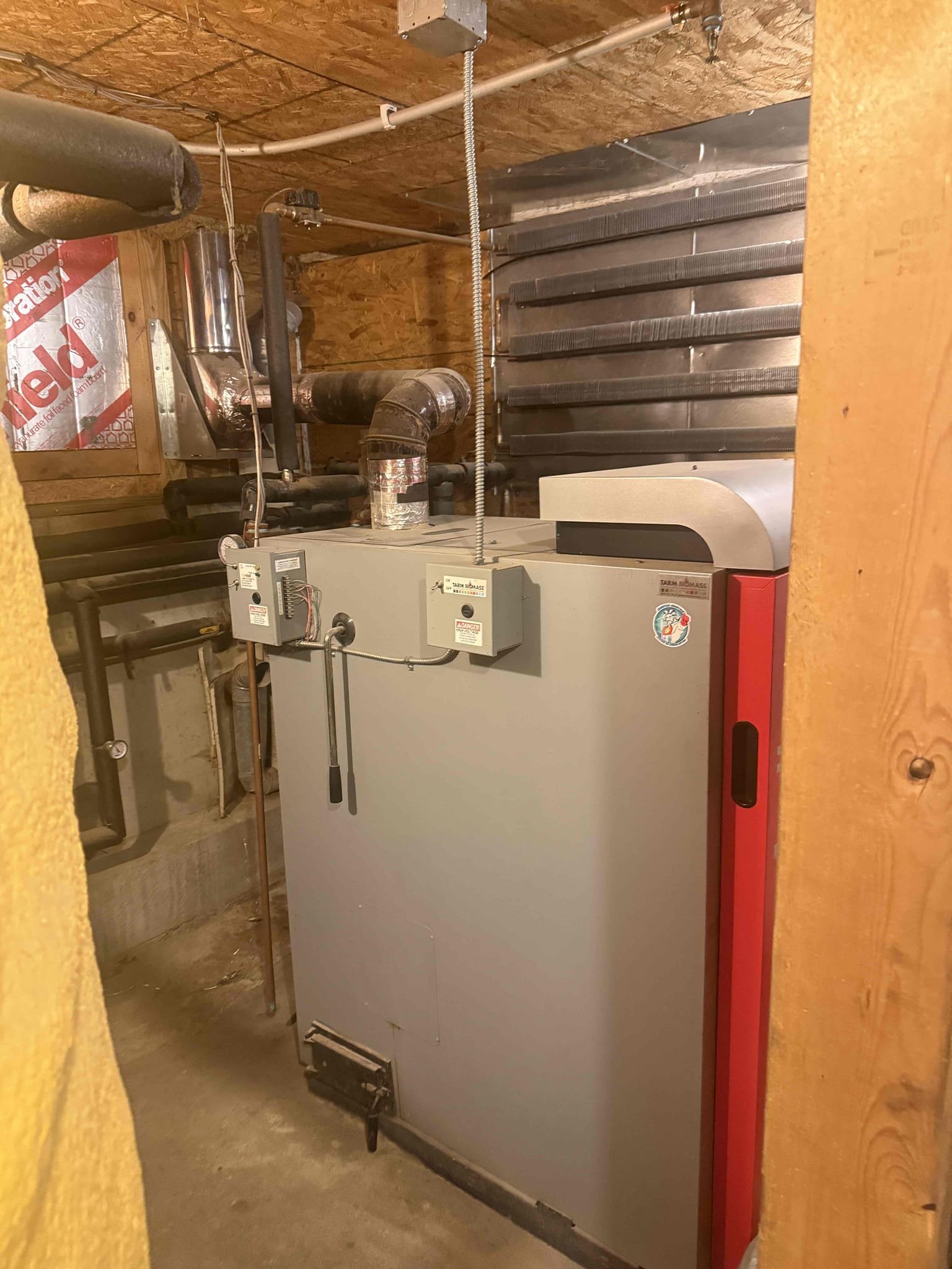 Customer reported insufficient heat in the first-floor master bedroom.

Upon inspection, I found the oil-fired Viessmann boiler supplying multiple cast-iron radiator hot water loops throughout the home. The system is also piped into a separate mechanical room with an additional manifold and large storage/storage buffer tanks connected to the boiler.

Based on system layout, heating load, and current performance, the oil-fired Viessmann boiler appears undersized for the overall demand of this home when operating as the sole heat source. The boiler is running and attempting to satisfy all zones; however, due to the size of the residence and the number of heating loops, it is likely at or beyond its effective capacity. This would explain the lack of heat in certain areas, including the first-floor master bedroom.

Customer reported oil usage of approximately 250 gallons every two weeks. They also stated that the previous owners relied heavily on the wood boiler system and used minimal oil