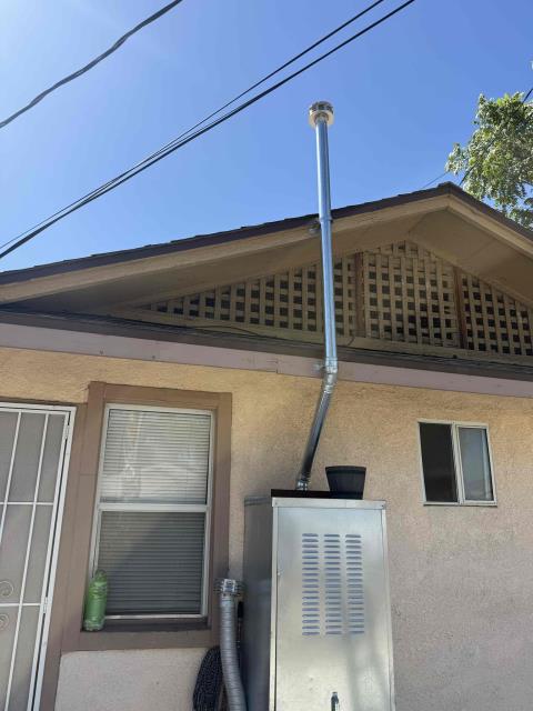 Upon arrival, the technician removed the existing water heater venting and the exterior water heater shed enclosure to gain proper access for the repair. The technician installed a new code-compliant water heater vent, ensuring the vent was properly secured with approved support straps while maintaining the required clearance away from the roof structure. A new vent cap was also installed at the termination to provide proper weather protection and safe venting of combustion gases. After installation, the technician verified that the venting system was properly aligned, securely supported, and operating as intended. The exterior water heater shed was reinstalled upon completion of the work, and the system was left in proper working order.
