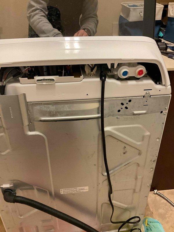 Responded to service call for leaking washing machine supply valves in a 12-year-old home. Diagnosed water damage beneath recessed laundry box with visible staining on wall. Replaced faulty washing machine valves and supply lines, restoring proper function and preventing further water damage.