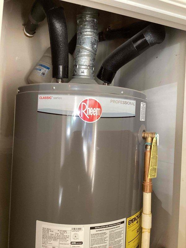 Performed diagnostic inspection on a 2-year-old Rheem Classic Series Professional gas tank water heater located in garage. Unit appears to be functioning properly with no visible damage, rust, or leakage; all connections, venting, and pressure relief valve were verified to be in good working condition.