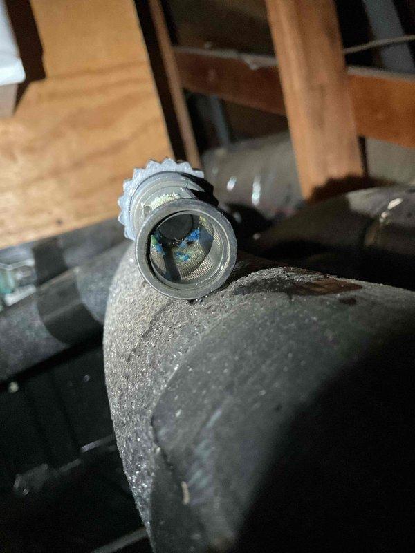 Completed documentation for previous service call by capturing required photographic evidence of kitchen sink installation and HVAC refrigerant line service port. Photos document existing conditions including stainless steel sink with chrome fixtures and insulated refrigerant piping with accessible service valve in crawlspace area.