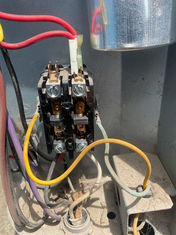 Responded to service call for system not keeping up with cooling demand. Upon arrival, performed diagnostic evaluation of split system with 6-year-old outdoor condenser unit and 26-year-old original indoor air handler. System has documented history of hard start issues and condenser problems, including failure to operate just days after previous maintenance visit requiring condenser kickstart.

Conducted comprehensive electrical diagnostics of contactor assembly and relay components. Measured capacitor performance using digital multimeter, recording microfarad readings to assess capacitor health and functionality. Inspected all electrical connections including dual contact points, terminal connections, and associated wiring harnesses. Observed moisture present on capacitor housing, indicating potential environmental exposure concerns.

Evaluated contactor condition and operation, examining silver-colored contact points and brass terminals for signs of pitting, burning, or degradation. 
