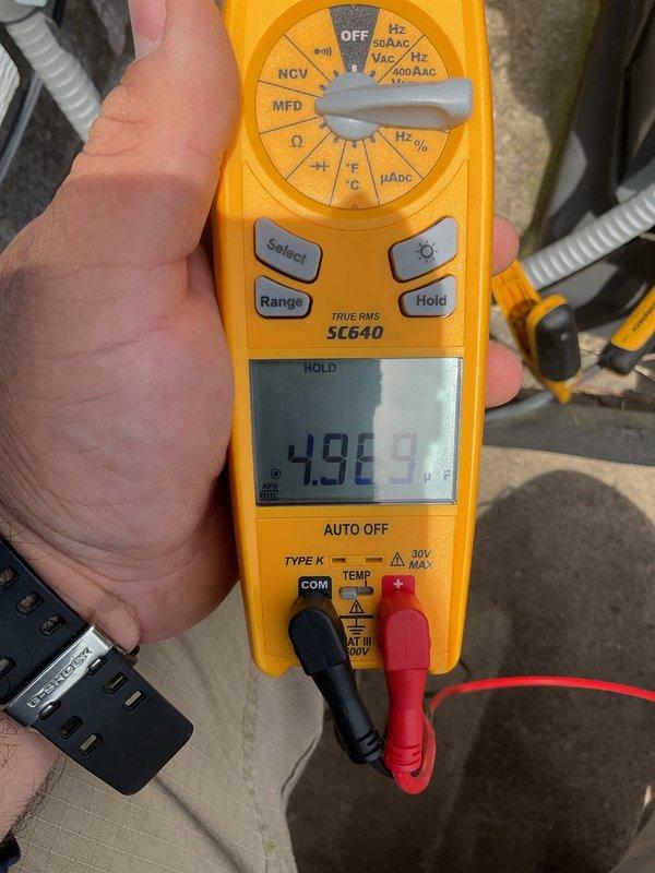 Responded to service call for system not keeping up with cooling demand. Upon arrival, performed diagnostic evaluation of split system with 6-year-old outdoor condenser unit and 26-year-old original indoor air handler. System has documented history of hard start issues and condenser problems, including failure to operate just days after previous maintenance visit requiring condenser kickstart.

Conducted comprehensive electrical diagnostics of contactor assembly and relay components. Measured capacitor performance using digital multimeter, recording microfarad readings to assess capacitor health and functionality. Inspected all electrical connections including dual contact points, terminal connections, and associated wiring harnesses. Observed moisture present on capacitor housing, indicating potential environmental exposure concerns.

Evaluated contactor condition and operation, examining silver-colored contact points and brass terminals for signs of pitting, burning, or degradation. 