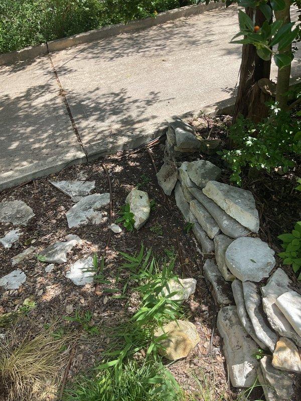 Completed follow-up service to address exposed landscape lighting wiring that remained unburied after previous repair work. Properly buried all low-voltage wiring runs throughout the landscaped areas adjacent to the concrete patio and mulched beds, ensuring code compliance and protection from environmental damage. Inspected and verified all wire connections and splices that were previously accessed during the tree lighting repair, confirming secure terminations and proper waterproofing. Tested system operation to ensure transformer functionality and proper voltage delivery to all fixtures, including the elevated tree lights approximately 20 feet above ground level. All landscape lighting wiring now properly concealed and protected per industry standards.