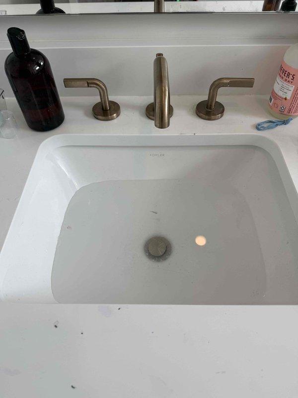 Responded to upstairs bathroom sink stoppage in 3-year-old residence. Successfully cleared drain obstruction in Kohler undermount lavatory basin using mechanical cable auger, restoring proper drainage and flow. Tested fixture operation with widespread faucet assembly to confirm complete clearance and verified no leaks at trap connections upon completion.