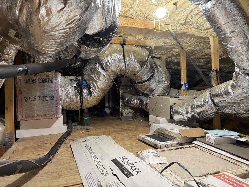 Responded to drain issue on 9-year-old HVAC system in attic location. Upon inspection, identified malfunctioning condensate drain system affecting one of two main systems in 4,760 square foot residence. Cleared primary and secondary drain lines, verified proper drainage flow, and tested drain pan functionality. Inspected thermostat control board (SYSTXZNSMS01 model) and verified proper communication with air handler unit. Examined extensive ductwork installation throughout attic space and confirmed all flexible duct connections remained secure. Cleared debris from attic work area surrounding air handler to ensure proper airflow and system access. System tested successfully with condensate draining properly through primary line, no overflow to secondary pan detected.