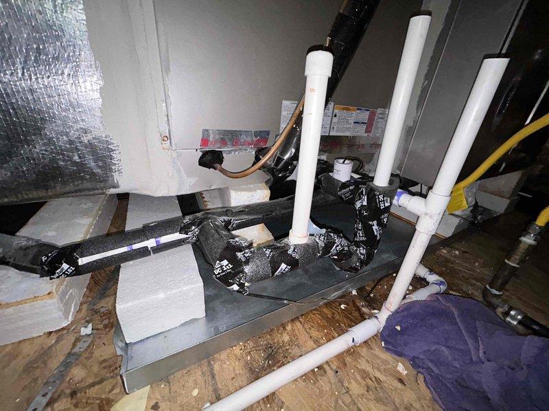 Responded to service call for reported leak on previously serviced HVAC system at vacant property. Upon arrival, accessed attic-mounted air handler unit and inspected condensate drain system. Identified leak source at primary drain line connection. Cleared condensate drain lines, verified proper drainage flow, and secured all PVC drain connections. Tested system operation to confirm no active leaking and proper condensate removal. All drain lines flowing freely with no backup or overflow conditions observed.