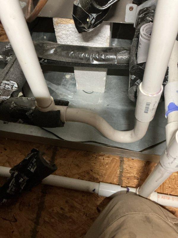 Responded to a not keeping up call at a vacant property with two HVAC systems and a mini-split. Performed diagnostic evaluation on system number two, a nine-year-old unit located in the attic. Inspected air handler, condensate drain pan assembly, and associated refrigerant lines. Verified proper installation of drainage system including PVC condensate lines and overflow pan. Checked routing of refrigerant lines and insulation integrity on copper tubing. Documented system configuration and component conditions through photographic records showing furnace/air handler with coiled flexible duct connections, multiple PVC drain lines with proper pitch and connections, and refrigerant line penetrations through attic space. All mechanical components and piping arrangements were accessible for inspection in the attic installation area.