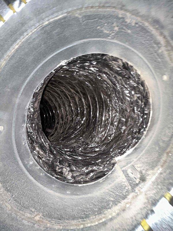 Completed warranty follow-up duct cleaning on single-zone HVAC system located in attic. Thoroughly cleaned flexible ductwork throughout system, removing accumulated dust, debris, and contamination from interior surfaces of supply and return ducts. Verified evaporator coil condition and proper airflow, ensuring all ductwork connections remain properly sealed following previous mastic application. System operating efficiently with no hot or cold spots reported.