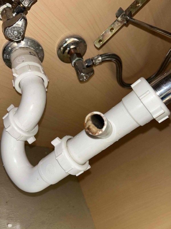 Responded to drainage issue at residential property with three HVAC systems, main system located in attic of 19-year-old home. Upon arrival, found bathroom sink basin with standing water and visible debris, indicating drainage obstruction. Inspected under-sink plumbing configuration and identified slow drain condition in P-trap assembly. Cleared blockage from white PVC drain pipes and P-trap using appropriate tools and techniques. Verified proper water flow through drain system and confirmed chrome drain flange connection integrity. Tested drainage performance with multiple water flow cycles to ensure complete resolution of standing water issue. All plumbing components, including compression fittings and slip joints, inspected and confirmed in proper working condition upon completion.