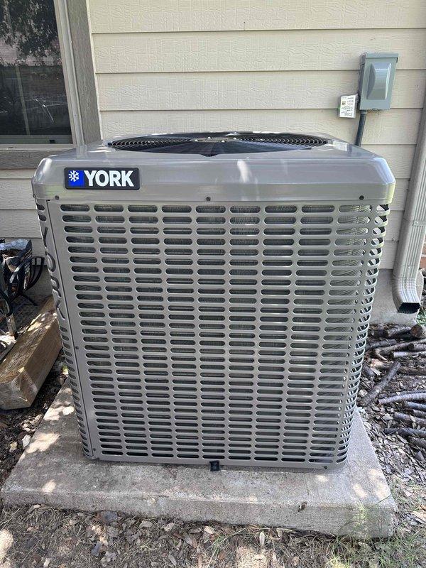 Completed sales consultation for complete HVAC system replacement at residential property. Customer approved for financing and requested temporary portable unit for living room during installation, as family has been displaced to master bedroom. Existing concrete pad in satisfactory condition for new equipment installation, eliminating need for additional pad preparation. Documented current York brand outdoor condensing unit positioned on exterior concrete pad with proper clearances, refrigerant line sets, and electrical disconnect in place for reference during replacement process.