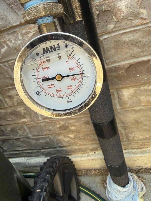 Completed annual plumbing maintenance inspection at a 2,105 square foot residential property. Performed comprehensive evaluation of the gas tank water heater located in the garage, which is now 7+ years old. Inspected pressure relief valve operation, checked for signs of corrosion or leakage around tank base and connections, verified proper venting and combustion air supply, and assessed overall unit condition. Monitored system pressure readings via installed gauge, which showed normal operating parameters. Examined all visible plumbing connections, shut-off valves, and gas line fittings for integrity. Documented current equipment status with photographic records showing pressure gauge readings and general system condition. All components found functioning within normal parameters at time of inspection, with unit showing expected wear consistent with age.