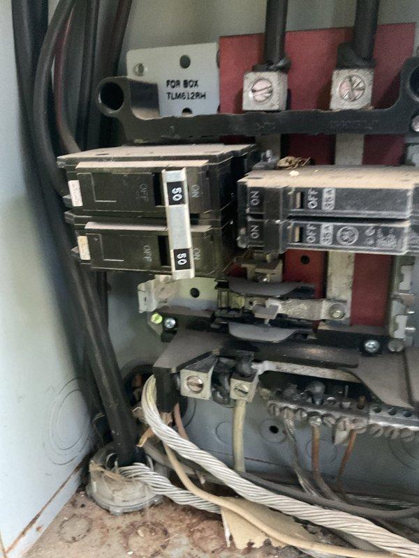 Responded to no power condition affecting HVAC system in 1980s residence. Inspected electrical panel located in laundry room and identified tripped breaker associated with air conditioning unit. Examined panel interior, verified proper bus bar connections, and assessed circuit breaker functionality. Reset affected breaker and confirmed power restoration to HVAC system. Documented panel condition with photographs showing existing breaker configuration and main feed connections for service records.