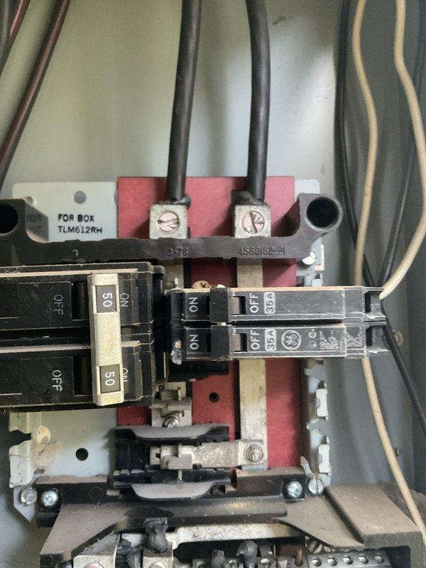 Responded to no power condition affecting HVAC system in 1980s residence. Inspected electrical panel located in laundry room and identified tripped breaker associated with air conditioning unit. Examined panel interior, verified proper bus bar connections, and assessed circuit breaker functionality. Reset affected breaker and confirmed power restoration to HVAC system. Documented panel condition with photographs showing existing breaker configuration and main feed connections for service records.