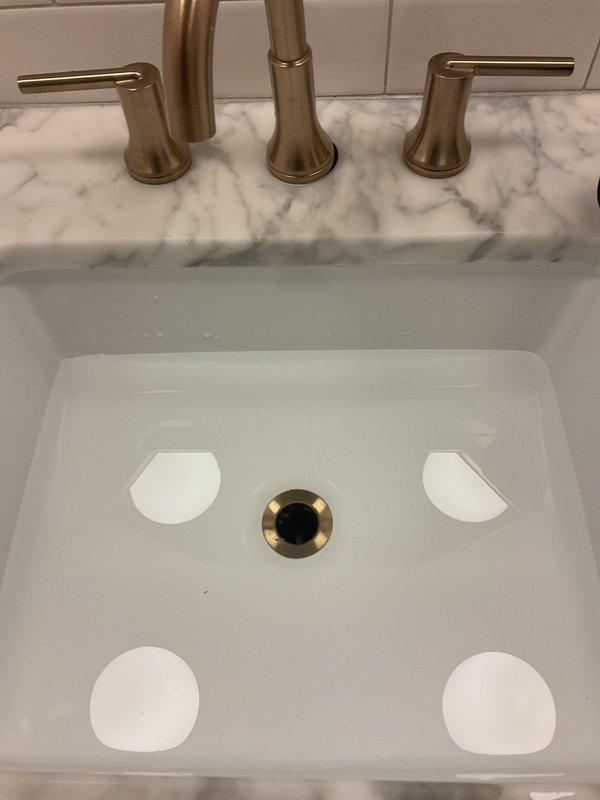 Responded to bathroom sink overflow caused by drain stoppage. Cleared obstruction from P-trap assembly beneath porcelain drop-in sink using mechanical methods. Verified proper drainage flow through PVC waste line and confirmed trap seal integrity. System restored to normal operation with no leaks detected.
