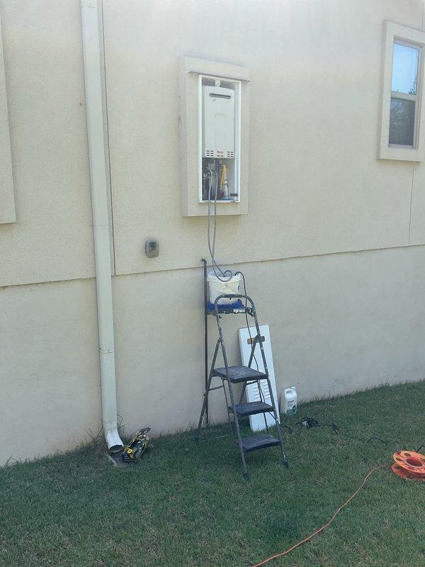 Completed comprehensive plumbing maintenance inspection on residential property with two exterior-mounted water heating units. Performed initial baseline assessment of wall-mounted tankless water heater system located in exterior alcove, documenting unit configuration, ventilation, gas and water connections, and overall serviceability. Conducted interior plumbing fixture inspection including toilet operation and functionality. Documented current condition of both water heating units, noting 7+ year age classification, and established maintenance baseline for future service intervals.