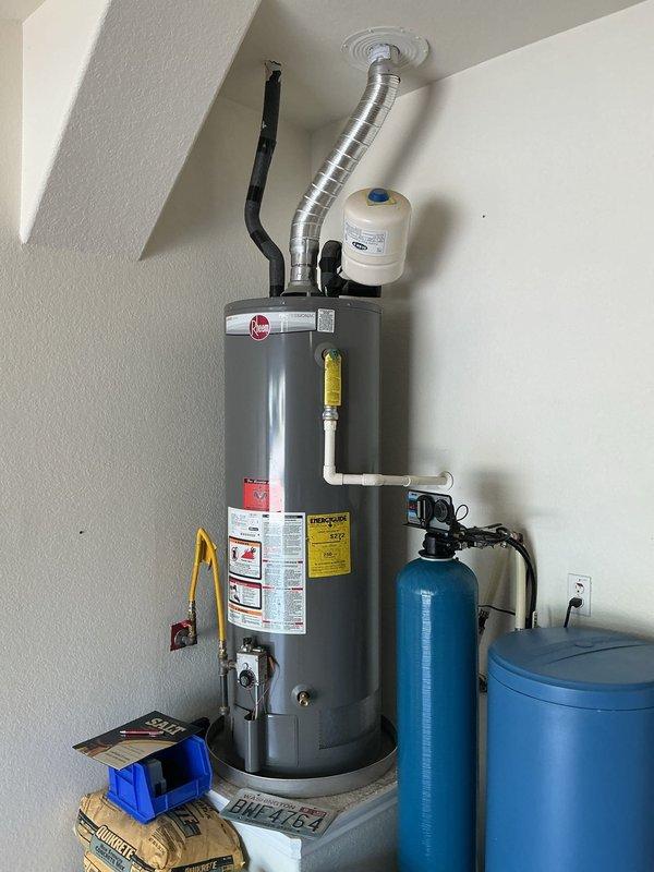 Replaced 11-year-old gas tank water heater located in garage. Disconnected and removed existing unit, including gas line, water supply lines, and venting system. Installed new gas tank water heater with proper venting through ceiling exhaust, reconnected gas supply line, cold water inlet, and hot water outlet connections. Verified recirculating system integration and proper operation. Inspected adjacent water softener system and confirmed operational status. Tested water pressure at exterior hose bib, reading normal PSI levels. Ensured all connections were secure, tested for gas leaks, verified pilot light ignition, and confirmed proper water flow throughout the system.