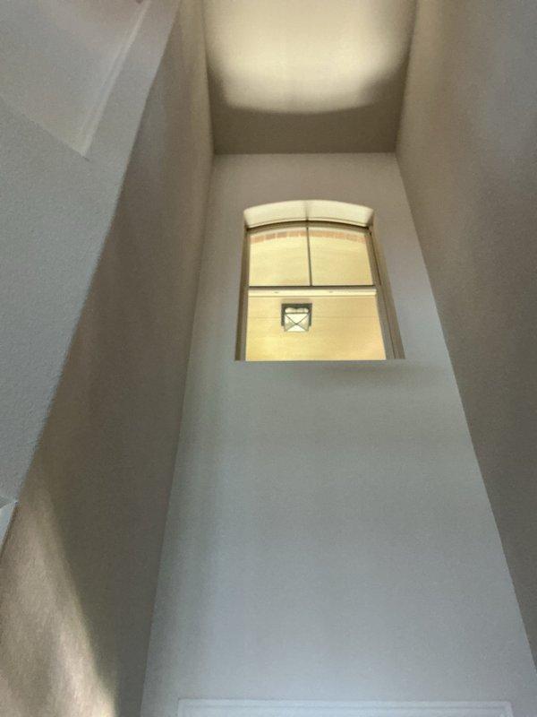 Responded to chirping smoke detector complaint at 3,337 sqft residence with vaulted ceilings. Replaced all 8-10 hardwired smoke detectors that had reached their 10-year service life with new long-life units, including specialized installation on vaulted ceiling areas requiring extended ladder access. Additionally addressed flickering foyer lighting circuit and replaced failed LED fixture previously installed by our team, restoring full functionality to all lighting zones.