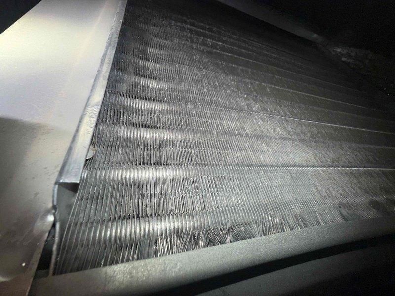 Completed routine maintenance inspection on dual HVAC systems located in attic of 3,370 square foot residence. Both systems are 2 years old and operating within normal parameters per homeowner report. Performed visual inspection of evaporator coils, noting moderate dust and debris accumulation on aluminum fins requiring attention. Documented condition of electrical panel serving HVAC systems, observing proper labeling of upstairs AC circuit. Systems maintaining adequate temperature control with no reported hot or cold spots throughout home. Recommended follow-up on previously quoted cleaning and fogging services to address observed coil contamination and optimize system efficiency.