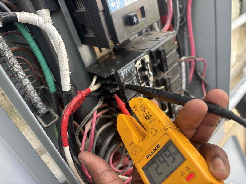 Responded to service call for unlabeled electrical panel serving newer HVAC unit located on left side of property. Performed diagnostic testing using Fluke multimeter to identify correct breaker for the transformer model unit. Successfully traced and verified circuit connections within main electrical panel, measuring voltage readings of 279V during testing process. Documented panel configuration showing multiple circuit breakers with various amperage ratings (40A, 50A) and custom jumper wire connections linking multiple circuits. Identified and confirmed proper breaker assignment for the specified HVAC equipment despite absence of panel labeling, ensuring safe operation and future serviceability of the system.