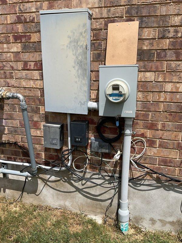 Responded to service call for two electrical issues: non-operational ceiling fan and loss of power to exterior outlets. Investigated main electrical panel and exterior service equipment for potential circuit breaker trips or GFCI faults. Reviewed previous installation history of back porch outlet and outdoor lighting system to determine warranty coverage applicability. Inspected exterior electrical panel, meter base, and associated conduit connections for signs of weather damage, loose connections, or component failure. Traced circuits from breaker panel to affected ceiling fan location and exterior receptacles to isolate fault points. Verified proper grounding and bonding at exterior electrical equipment mounted on brick wall. Documented equipment condition with photographic evidence showing exterior service entrance and utility connections.