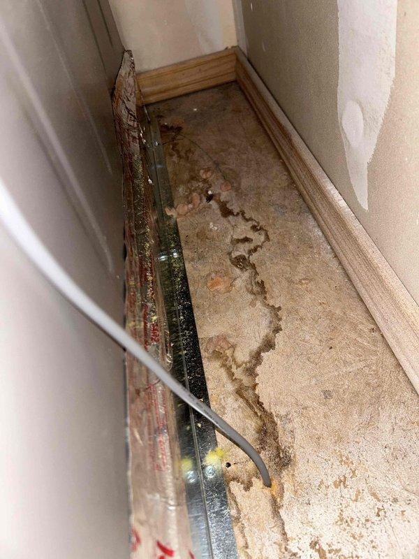 Responded to emergency service call for 2-month-old HVAC system causing active water leak through ceiling into living space. Upon arrival, found significant water damage to ceiling and carpet with visible staining and saturation patterns indicating ongoing condensate drain issue. Marked ceiling for access panel installation to address leak source at air handler drain pan. Documented extensive water intrusion damage affecting interior finishes including carpet discoloration and potential ceiling drywall replacement needs.