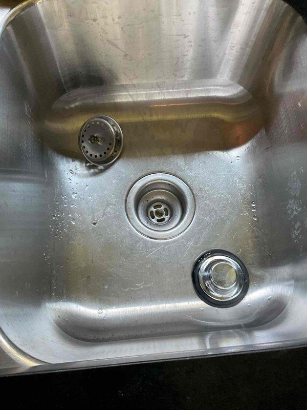 Responded to clogged kitchen sink in 1980s residence. Upon arrival, confirmed complete drainage blockage in stainless steel basin. Deployed professional drain cleaning equipment and accessed P-trap assembly beneath cabinet. Cleared obstruction from drain line using mechanical auger, restoring full water flow and proper drainage. Tested system to verify complete resolution and left work area clean.