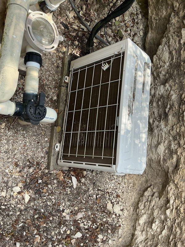 Responded to service call for guest house mini-split system with inadequate cooling performance. Upon arrival, performed comprehensive diagnostic evaluation of the 7-year-old ductless mini-split system including inspection of the outdoor condensing unit, refrigerant lines, and electrical connections. Visually assessed the outdoor unit positioned on gravel pad adjacent to building exterior, noting weathered housing and accumulated environmental debris on protective grille and coil surfaces. Checked refrigerant line connections, electrical conduit routing, and mounting hardware for proper installation and secure attachment points. Evaluated system operation, airflow patterns, and temperature differential across the evaporator coil. Documented equipment condition through photographic documentation showing outdoor condensing unit placement, associated plumbing infrastructure, and overall installation environment. Provided technical findings and recommended corrective actions to restore opt