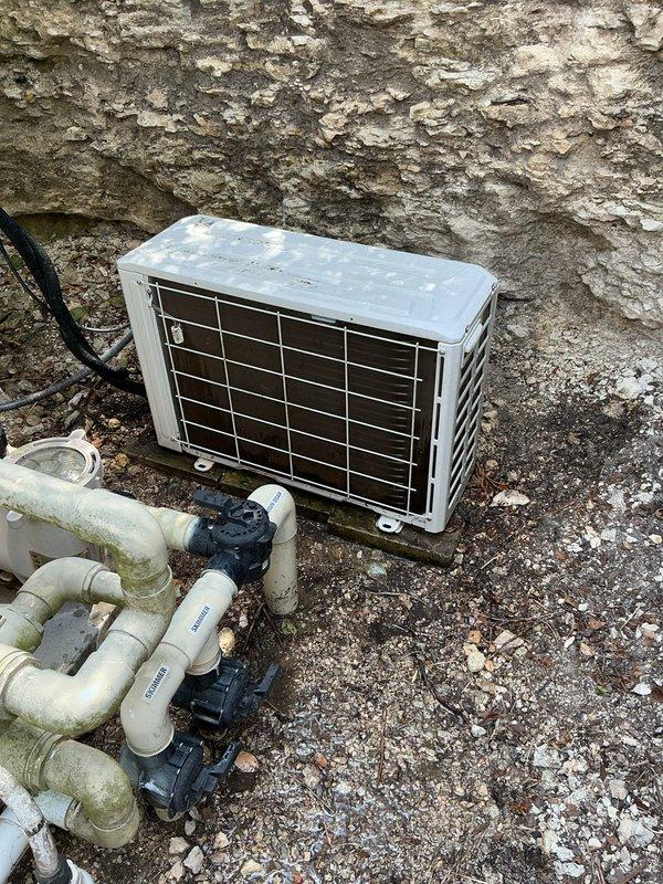Responded to service call for guest house mini-split system with inadequate cooling performance. Upon arrival, performed comprehensive diagnostic evaluation of the 7-year-old ductless mini-split system including inspection of the outdoor condensing unit, refrigerant lines, and electrical connections. Visually assessed the outdoor unit positioned on gravel pad adjacent to building exterior, noting weathered housing and accumulated environmental debris on protective grille and coil surfaces. Checked refrigerant line connections, electrical conduit routing, and mounting hardware for proper installation and secure attachment points. Evaluated system operation, airflow patterns, and temperature differential across the evaporator coil. Documented equipment condition through photographic documentation showing outdoor condensing unit placement, associated plumbing infrastructure, and overall installation environment. Provided technical findings and recommended corrective actions to restore opt
