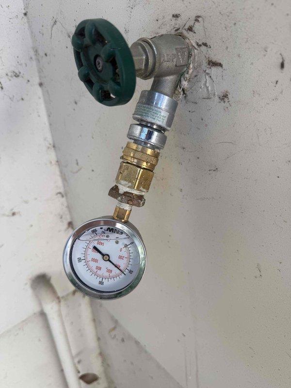 Responded to service call for 5-year-old tankless water heater experiencing intermittent shutdown issues. Upon arrival, performed comprehensive diagnostic evaluation of the unit including error code analysis, inspection of digital controller display, verification of gas supply line connections, and assessment of water flow components. Examined venting system for proper operation and clearances. Inspected inlet water filtration system and pressure regulation equipment, noting pressure gauge reading at zero PSI which indicated potential water supply or pressure regulator malfunction. Evaluated all brass and copper plumbing connections, shut-off valves, and compression fittings throughout the system. Identified damaged components in lower cabinet section that required attention. Checked electrical connections and wiring to controller board. Assessed condition of gas flex line and associated safety shut-off valves. Documented system configuration with detailed photography of pressure monit