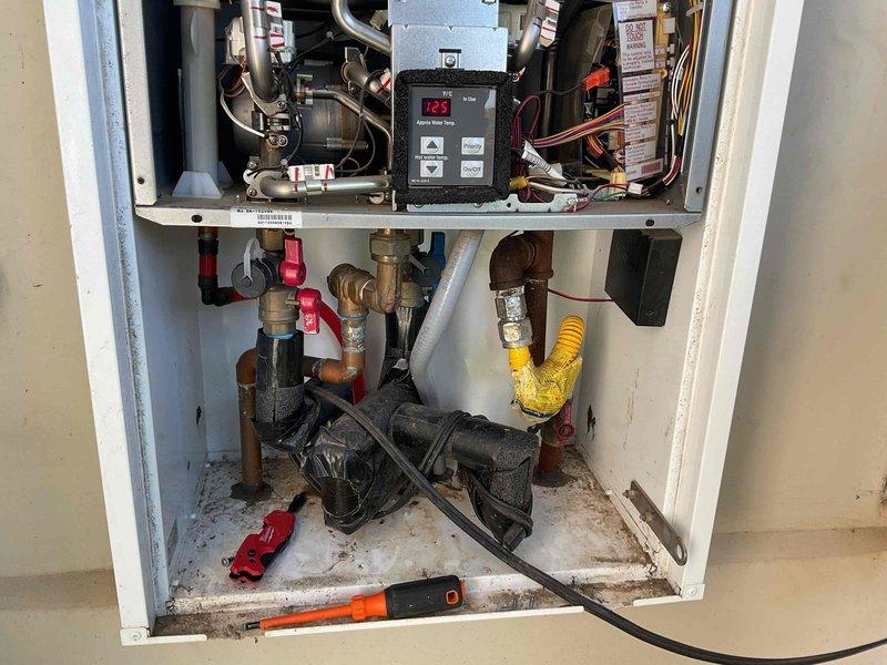 Responded to service call for 5-year-old tankless water heater experiencing intermittent shutdown issues. Upon arrival, performed comprehensive diagnostic evaluation of the unit including error code analysis, inspection of digital controller display, verification of gas supply line connections, and assessment of water flow components. Examined venting system for proper operation and clearances. Inspected inlet water filtration system and pressure regulation equipment, noting pressure gauge reading at zero PSI which indicated potential water supply or pressure regulator malfunction. Evaluated all brass and copper plumbing connections, shut-off valves, and compression fittings throughout the system. Identified damaged components in lower cabinet section that required attention. Checked electrical connections and wiring to controller board. Assessed condition of gas flex line and associated safety shut-off valves. Documented system configuration with detailed photography of pressure monit