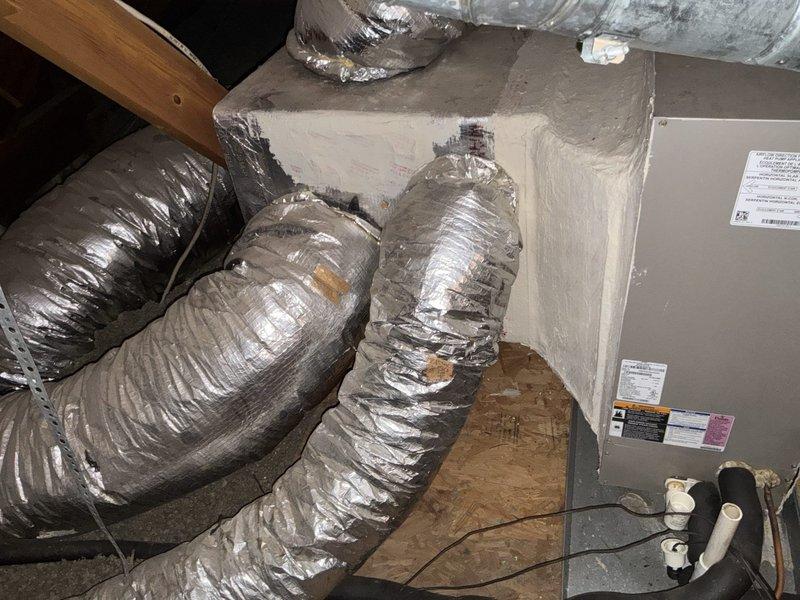 Conducted sales consultation for residential HVAC system replacement. Evaluated existing attic-mounted air handler unit with flexible metallic ductwork and assessed current system performance. Documented equipment specifications and photographed installation configuration including duct routing, electrical connections, and PVC condensate drain components. Reviewed thermostat operation showing current indoor temperature of 86°F with cooling setpoint at 59°F, indicating system actively running to meet demand. Provided recommendations for complete system upgrade to improve efficiency and comfort control.