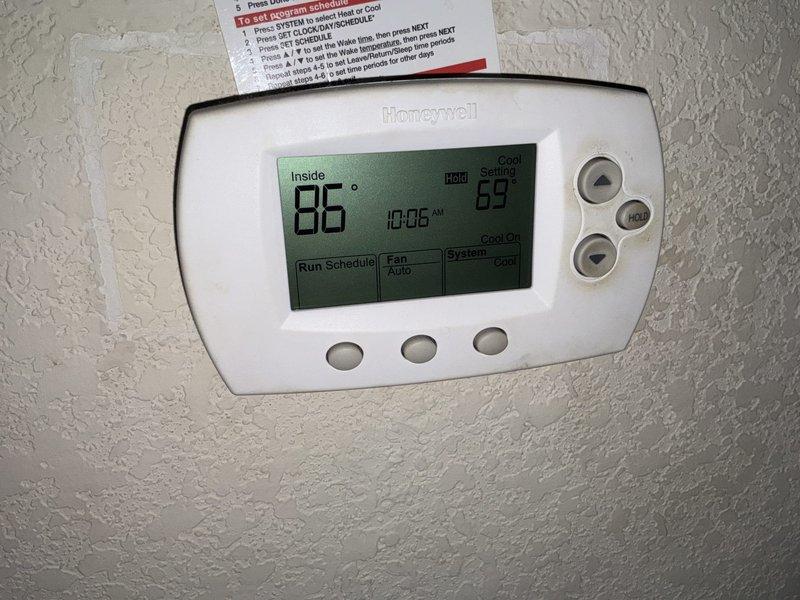 Conducted sales consultation for residential HVAC system replacement. Evaluated existing attic-mounted air handler unit with flexible metallic ductwork and assessed current system performance. Documented equipment specifications and photographed installation configuration including duct routing, electrical connections, and PVC condensate drain components. Reviewed thermostat operation showing current indoor temperature of 86°F with cooling setpoint at 59°F, indicating system actively running to meet demand. Provided recommendations for complete system upgrade to improve efficiency and comfort control.