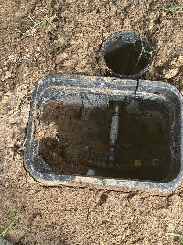 Responded to return service call for recurring leak at outdoor water shutoff valve. Upon inspection, found valve box flooded with standing water and corroded fittings indicating ongoing leak at main shutoff assembly. Replaced entire shutoff valve assembly including gate valve, fittings, and connections. Excavated and cleared debris from valve box, removed sediment buildup, and installed new valve hardware. Tested system for proper operation and verified no active leaks at completion.