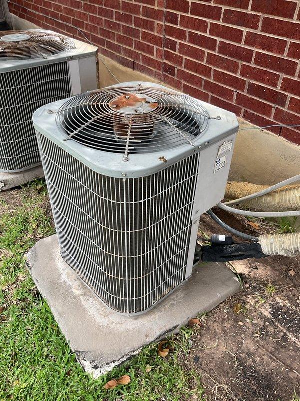 Completed comprehensive maintenance inspection on two 22-year-old HVAC systems located in attic, addressing reported cooling performance concerns during high-temperature conditions. Inspected both condenser units positioned exterior on concrete pads, noting visible corrosion on top fan assemblies and evaluating heat exchanger coil condition. Verified condensate drain line routing and float switch operation in attic installation, inspecting PVC drainage system for proper flow and clearing potential blockages. Evaluated system airflow, refrigerant levels, electrical connections, and overall operational efficiency on both units to identify factors contributing to inadequate cooling performance on hot days.
