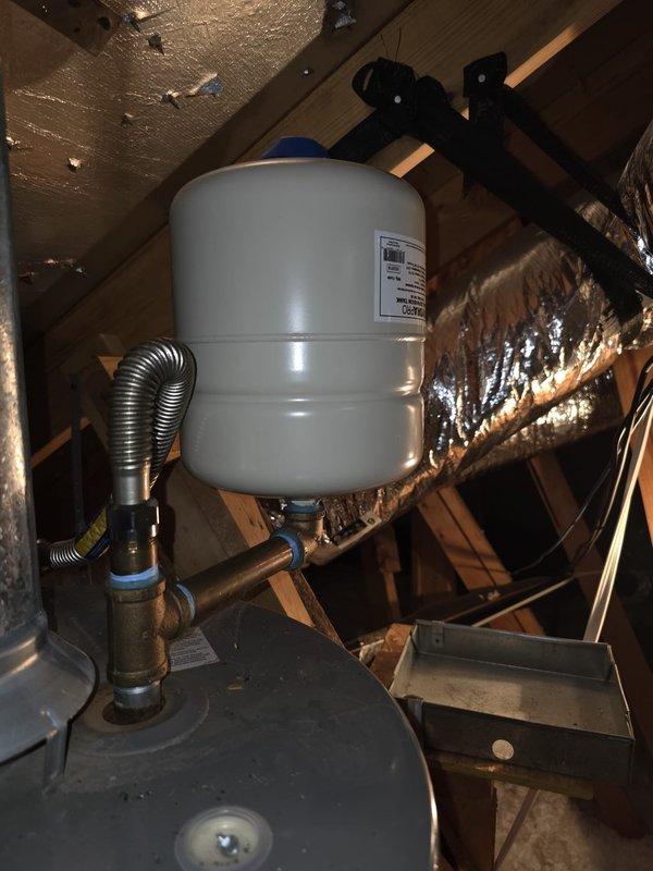 Completed routine maintenance flush on a 5-year-old residential water heater installed in attic space. Verified proper operation of pressure relief valve, inspected expansion tank mounting and connections, and confirmed system pressure readings within normal operating range. All components found to be functioning correctly with no leaks detected.