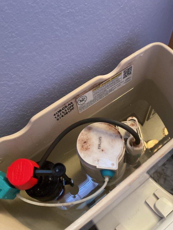 Responded to complaint of low water pressure throughout home and slow toilet tank refill times. Upon inspection, identified compromised fill valve assembly in toilet tank showing significant mineral buildup and discoloration on float mechanism. Tested water pressure at multiple fixtures to isolate issue. Disassembled and cleaned fill valve components, removing calcium and mineral deposits that were restricting water flow. Adjusted fill valve settings and refill tube positioning to restore proper flow rate and tank refill speed. Verified flush mechanism and flapper valve operation. Tested system multiple times to confirm adequate water pressure restoration and normal refill cycle timing. All components functioning within manufacturer specifications upon completion.