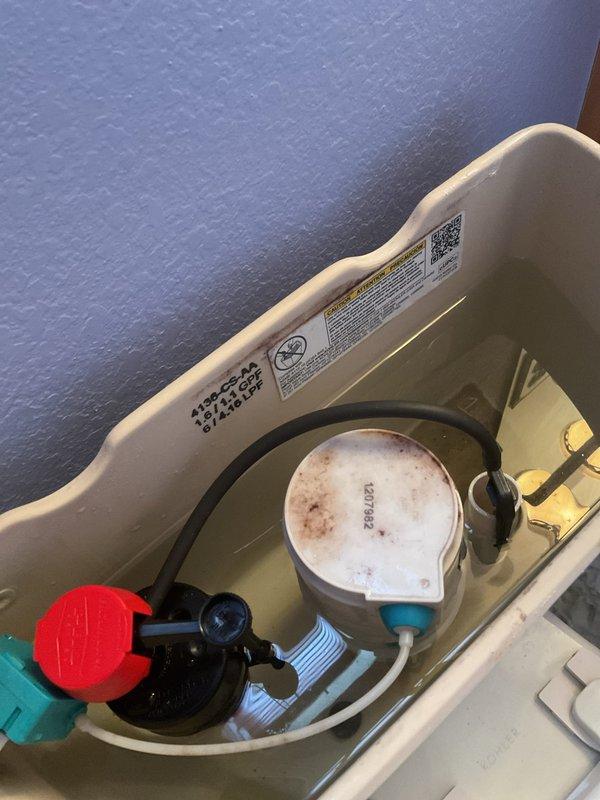 Responded to complaint of low water pressure throughout home and slow toilet tank refill times. Upon inspection, identified compromised fill valve assembly in toilet tank showing significant mineral buildup and discoloration on float mechanism. Tested water pressure at multiple fixtures to isolate issue. Disassembled and cleaned fill valve components, removing calcium and mineral deposits that were restricting water flow. Adjusted fill valve settings and refill tube positioning to restore proper flow rate and tank refill speed. Verified flush mechanism and flapper valve operation. Tested system multiple times to confirm adequate water pressure restoration and normal refill cycle timing. All components functioning within manufacturer specifications upon completion.